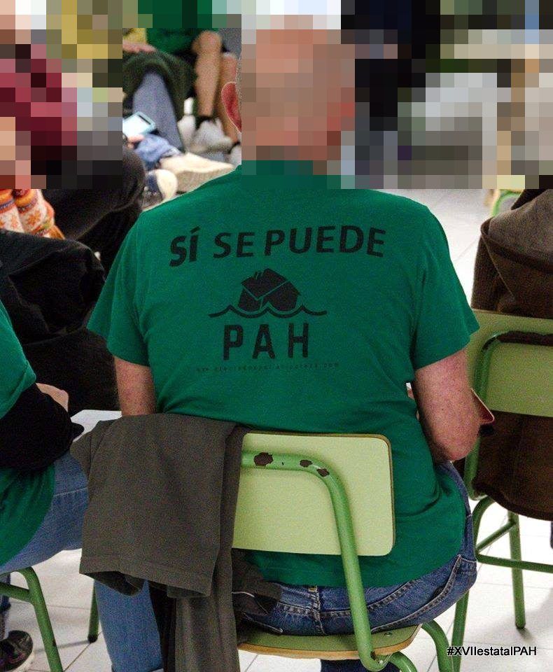 Activista de costas coa camiseta verde «Sí se puede» da PAH